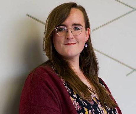 headshot of person with long brown hair and glasses hair